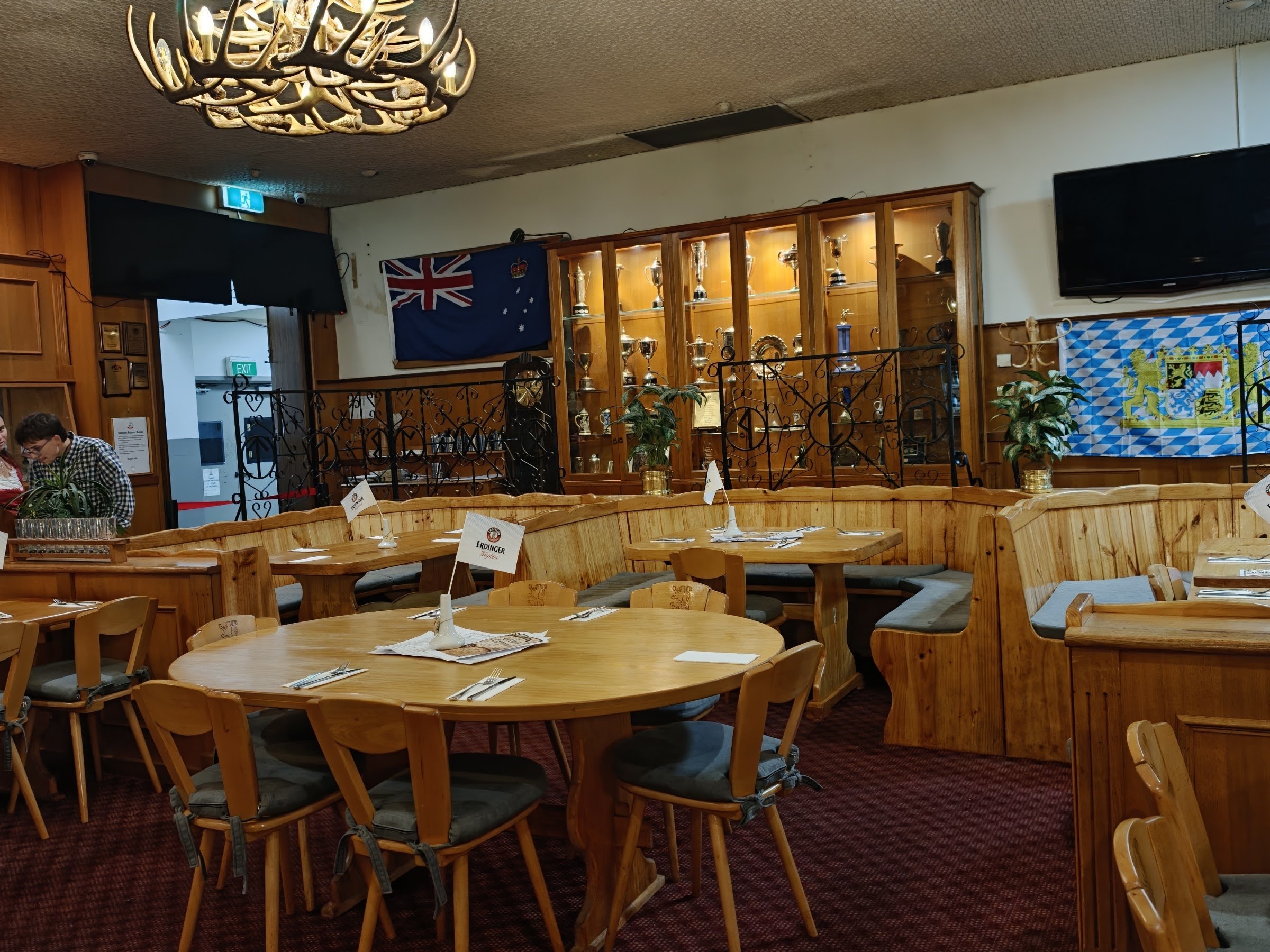The Bier Halle dining room with pine booths, round tables and flags