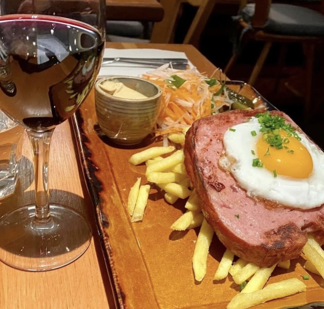 A German plate with a fried egg, chips and salad