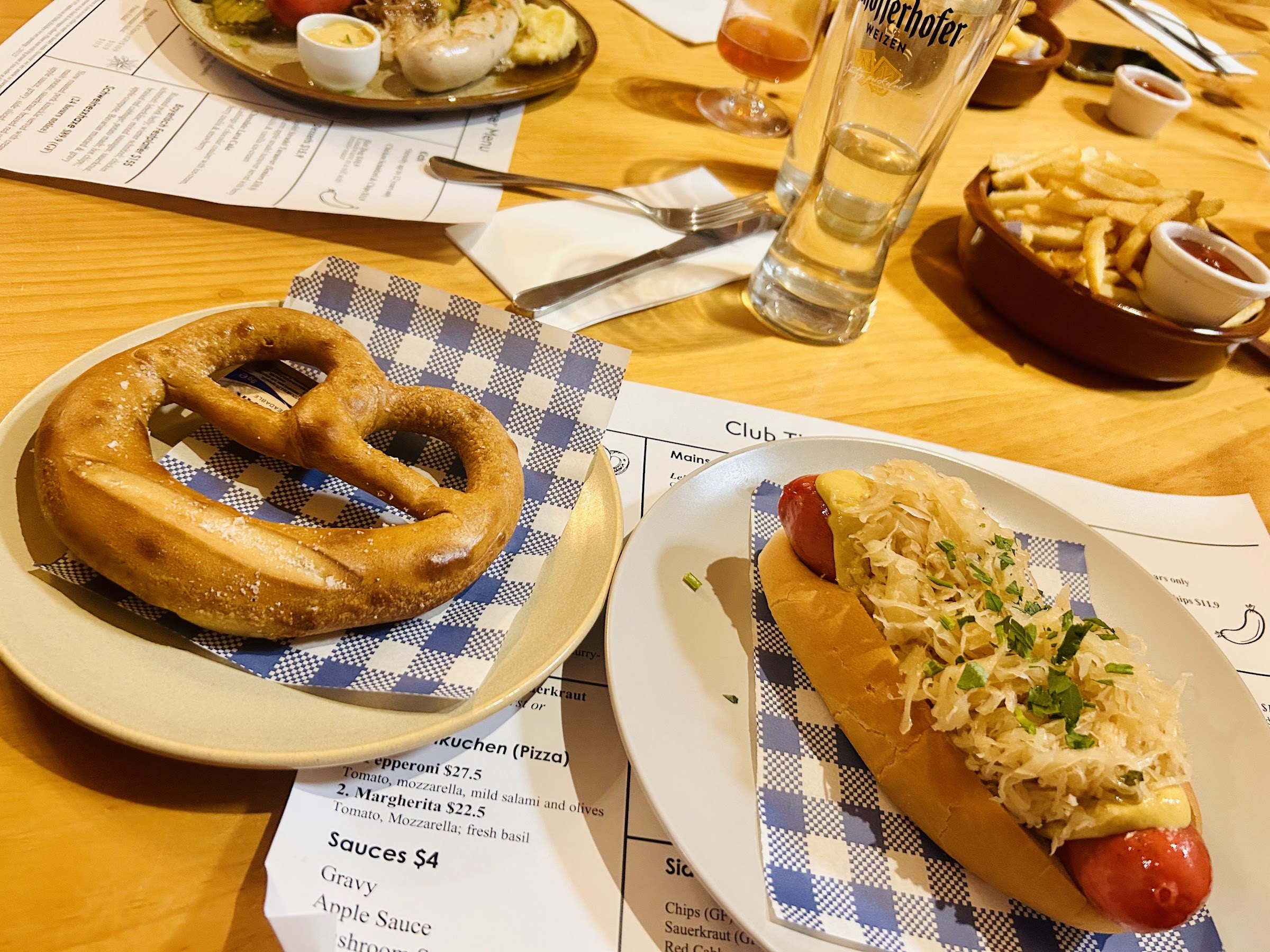 A pretzel and a sausage in a roll with sauerkraut